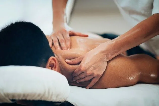 A man getting his back worked on the massage table.