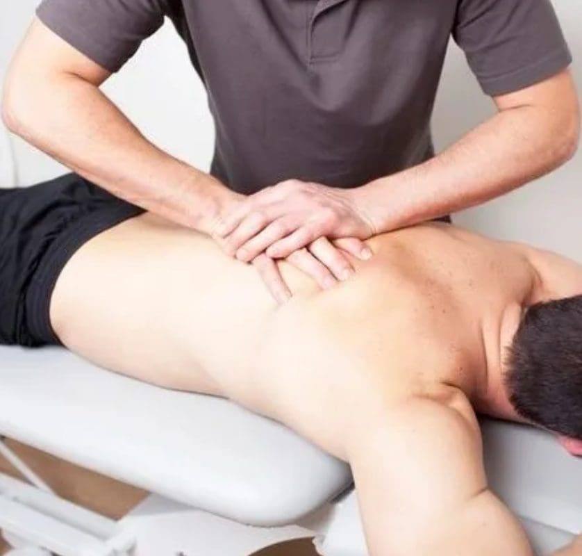 A man is getting his back examined by an osteopath.