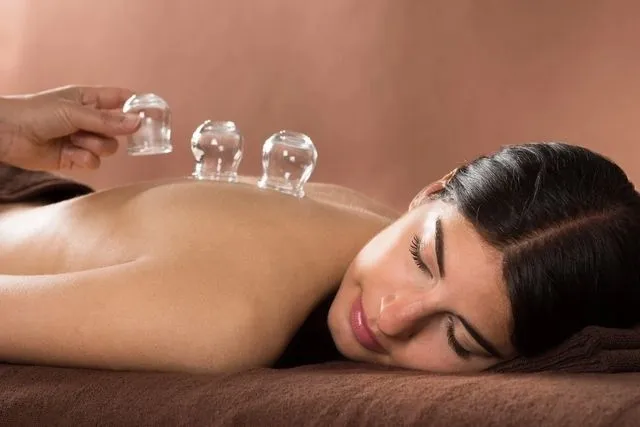 A woman is getting cupping on her back