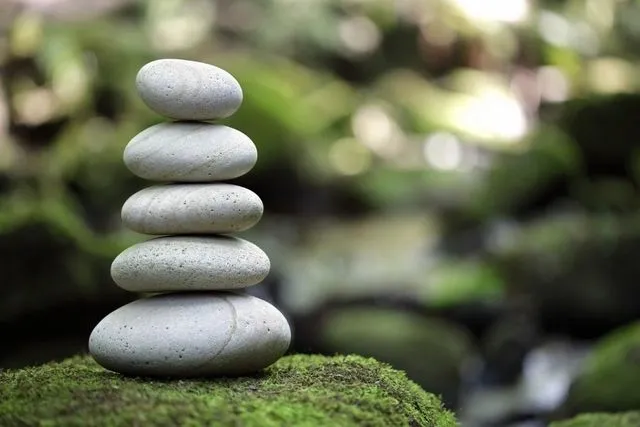 A stack of rocks sitting on top of a green mound.