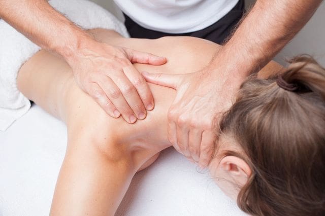 A person is getting their back examined by an osteopath.